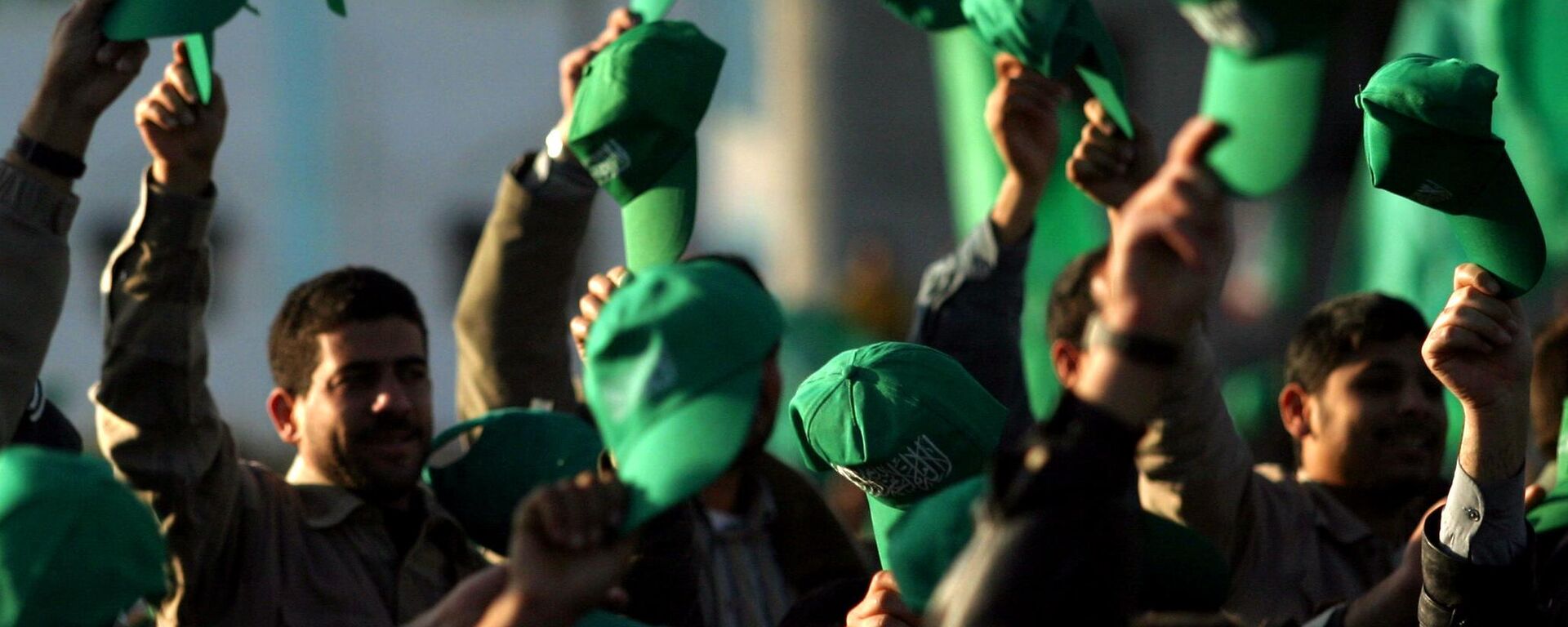Os apoiadores palestinos do Hamas erguem seus chapéus verdes durante uma manifestação celebrando a vitória do grupo nas eleições parlamentares, no Campo de Refugiados Khan Younis, no sul da Faixa de Gaza, em 27 de janeiro de 2006 - Sputnik Brasil, 1920, 06.01.2024