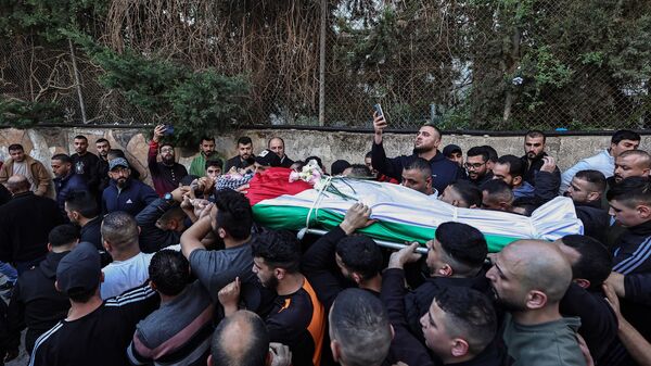 Palestinos carregam corpo de homem morto durante confrontos com as forças israelenses no campo de Qalandia, durante cortejo fúnebre fora do hospital do governo de Ramallah, Cisjordânia, 4 de dezembro de 2023 - Sputnik Brasil