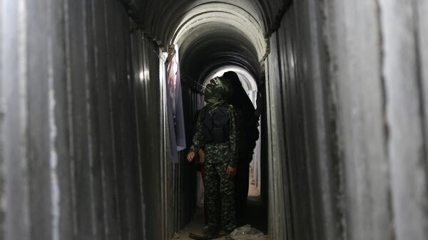 Um menino palestino caminha dentro de um túnel usado para exercícios militares durante uma exposição de armas em um acampamento de verão para jovens administrado pelo Hamas, na Cidade de Gaza, 21 de julho de 2016 - Sputnik Brasil