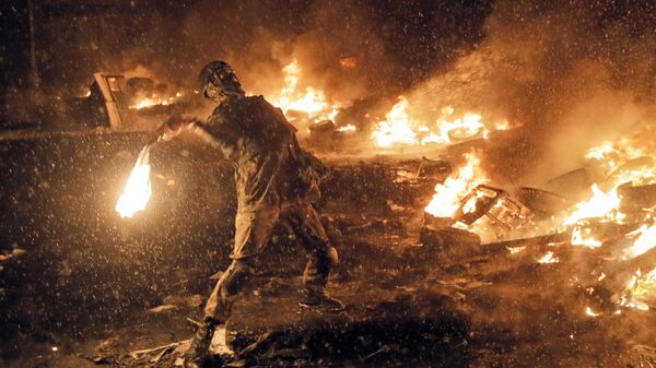Um manifestante lança um coquetel molotov durante confrontos com a polícia no centro de Kiev, Ucrânia. - Sputnik Brasil