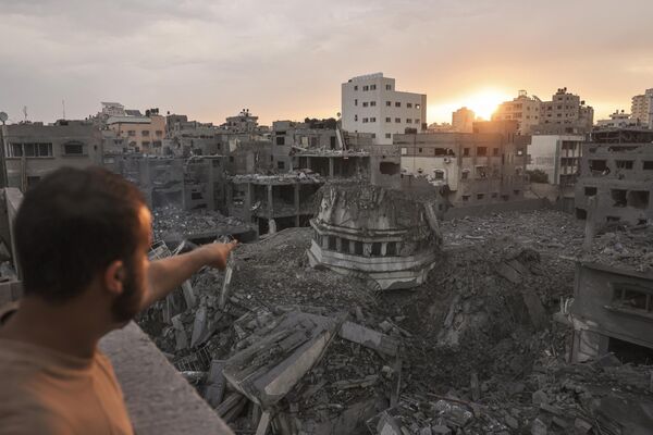 Um palestino aponta para a mesquita Ahmed Yassin, que foi destruída por ataques aéreos israelenses, cidade de Gaza, Palestina, 9 de outubro de 2023. - Sputnik Brasil