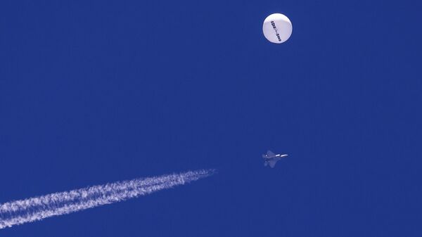 Um caça voa perto de um grande balão à deriva sobre o oceano Atlântico. Minutos depois, o balão foi atingido por um míssil de um caça F-22, encerrando sua travessia de uma semana sobre os EUA - Sputnik Brasil