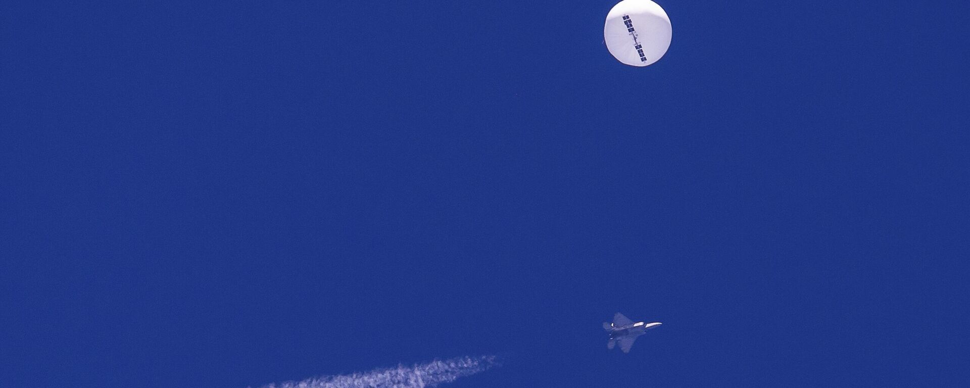 Um caça voa perto de um grande balão à deriva sobre o oceano Atlântico. Minutos depois, o balão foi atingido por um míssil de um caça F-22, encerrando sua travessia de uma semana sobre os EUA - Sputnik Brasil, 1920, 29.12.2023