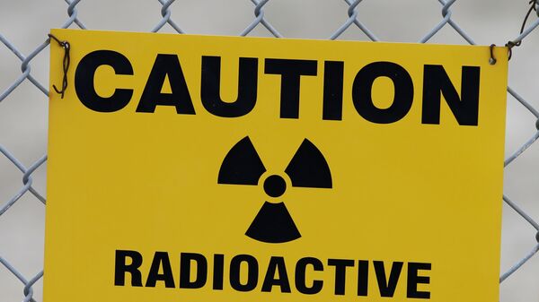 Placa de alerta de material radioativo está pendurada em uma cerca em frente a um prédio que abriga urânio empobrecido nas instalações da EnergySolutions em Clive, Utah, EUA, 6 de maio de 2015 - Sputnik Brasil