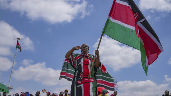 Uma mulher agita uma bandeira queniana durante as celebrações do 60º Dia de Jamhuri (Dia da Independência) do Quênia, em 12 de dezembro de 2023 - Sputnik Brasil