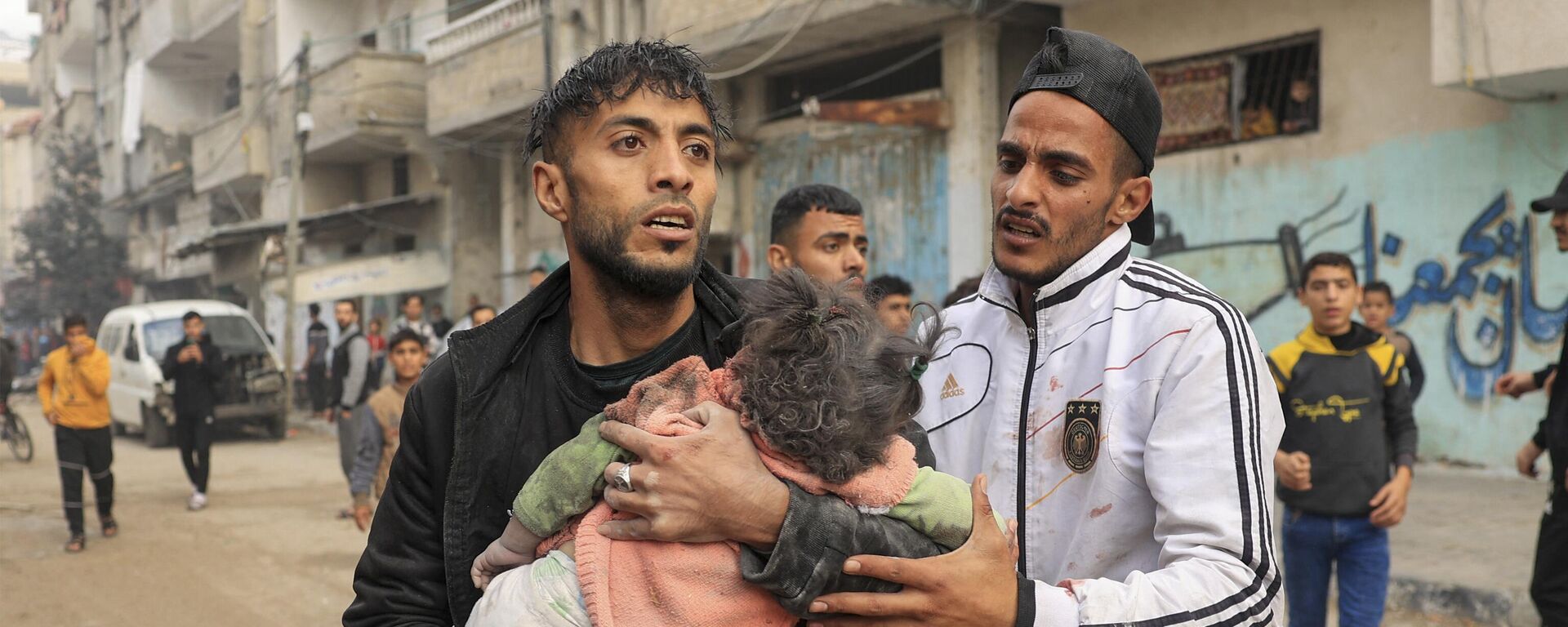 Um homem carrega uma criança ferida durante o bombardeio israelense em Rafah, no sul da Faixa de Gaza, em 14 de dezembro de 2023 - Sputnik Brasil, 1920, 15.12.2023