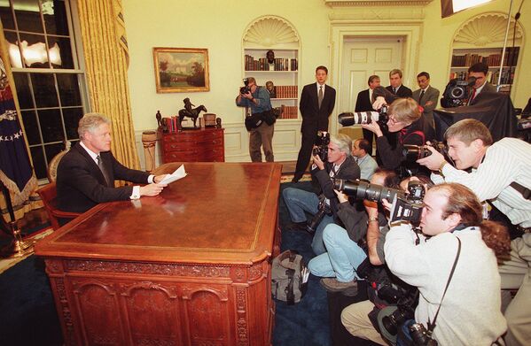 Fotógrafos tiram fotos do presidente norte-americano, Bill Clinton, enquanto ele se prepara para discursar perante a nação a partir da Casa Branca, em 16 de dezembro de 1998. Os comentários de Clinton foram feitos logo após Bagdá ter sido abalada por uma série de explosões e tiros antiaéreos. - Sputnik Brasil