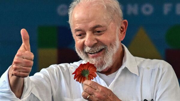 O presidente brasileiro, Luiz Inácio Lula da Silva, levanta o polegar segurando uma flor durante visita ao local onde será construído o conjunto habitacional Copa do Povo, em São Paulo, Brasil, no dia 16 de dezembro de 2023 - Sputnik Brasil