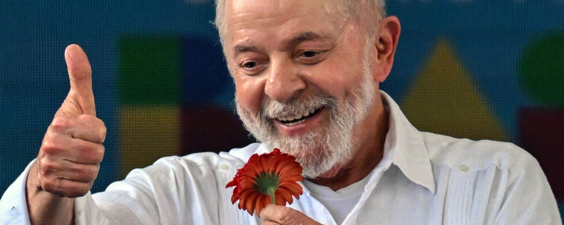 O presidente brasileiro, Luiz Inácio Lula da Silva, levanta o polegar segurando uma flor durante visita ao local onde será construído o conjunto habitacional Copa do Povo, em São Paulo, Brasil, no dia 16 de dezembro de 2023 - Sputnik Brasil, 1920, 16.12.2023