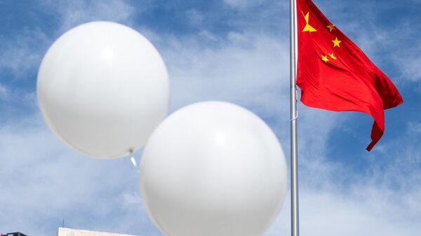 Dois balões brancos flutuam perto da bandeira chinesa enquanto o ativista Rev. Patrick Mahoney protesta contra o governo chinês sobre o suposto balão de vigilância chinês que foi abatido sobre os EUA na semana passada, durante uma manifestação do lado de fora da Embaixada da China em Washington, DC, 15 de fevereiro de 202 - Sputnik Brasil