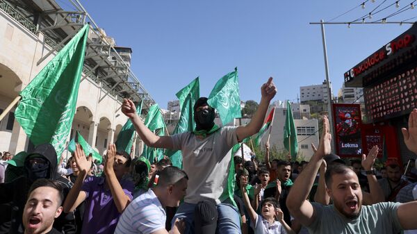 Palestinos erguem a bandeira verde do Hamas durante um protesto de apoiadores dos movimentos Fatah e Hamas enquanto se manifestam em apoio ao povo palestino após as orações do meio-dia de sexta-feira em Hebron, na Cisjordânia ocupada, em 3 de novembro de 2023 - Sputnik Brasil