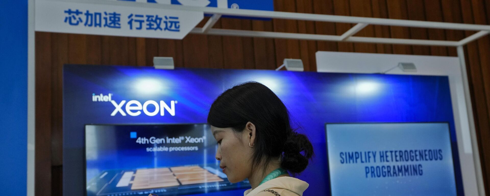 Mulher navega em seu smartphone perto de estande da Intel promovendo seus chips Xeon durante a Cúpula Wave em Pequim, China, 16 de agosto de 2023 - Sputnik Brasil, 1920, 22.12.2023