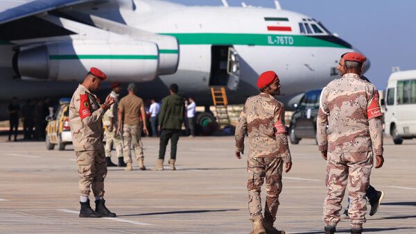 Militares supervisionam chegada de aeronave de transporte Ilyushin Il-76 do Corpo de Guardiões da Revolução Islâmica (IRGC, na sigla em inglês) transportando ajuda fornecida pelo Irã para os sobreviventes das enchentes que submergiram a cidade de Derna, no aeroporto de Benghazi, Líbia, 16 de setembro de 2023 - Sputnik Brasil