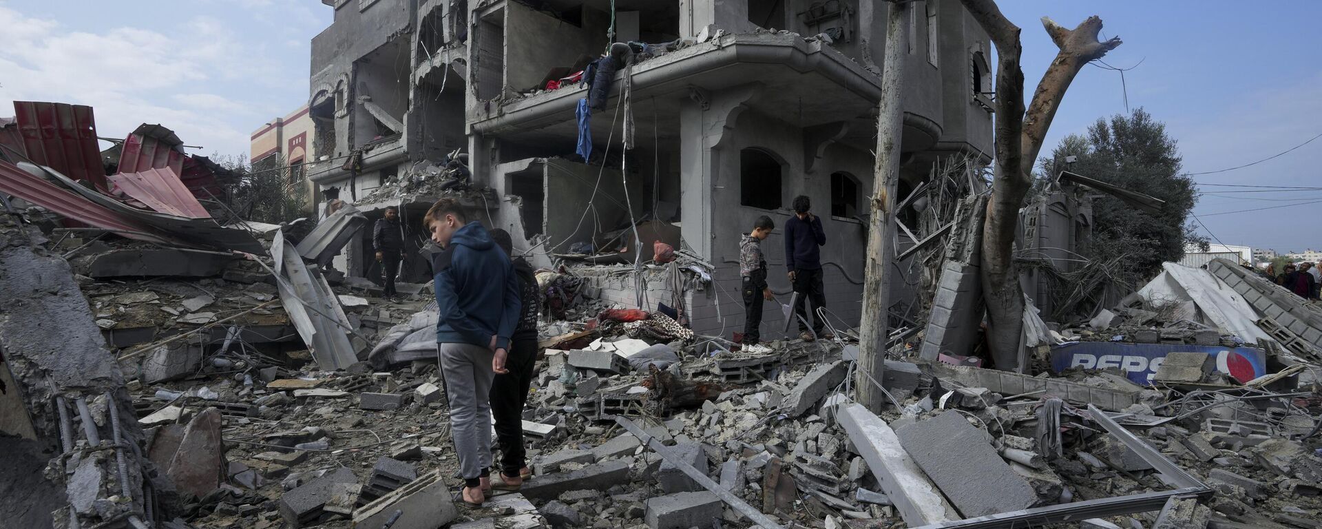 Famílias em meio a destroços após bombardeios intensos das Forças de Defesa de Israel (FDI) contra o campo de refugiados em Maghazi. Faixa de Gaza, 25 de dezembro de 2023 - Sputnik Brasil, 1920, 26.12.2023