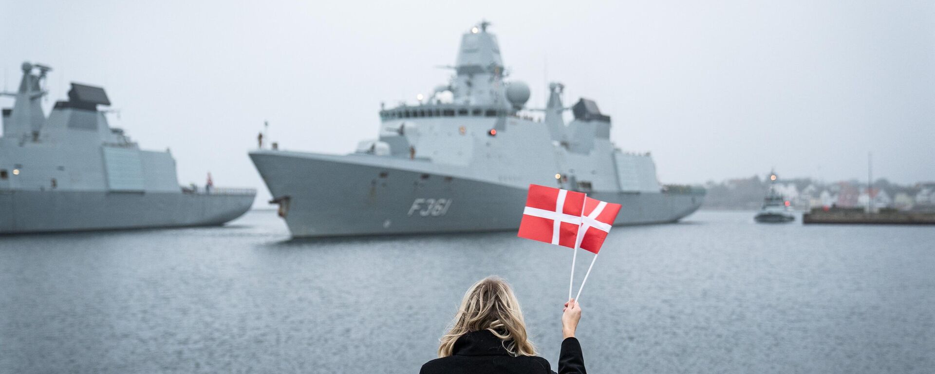 Bandeiras dinamarquesas dão boas-vindas à tripulação enquanto a fragata da Marinha dinamarquesa Iver Huitfeldt retorna para casa, na Dinamarca, após um destacamento de quatro meses em uma operação multinacional europeia no estreito de Ormuz, em 10 de dezembro de 2020 - Sputnik Brasil, 1920, 29.12.2023