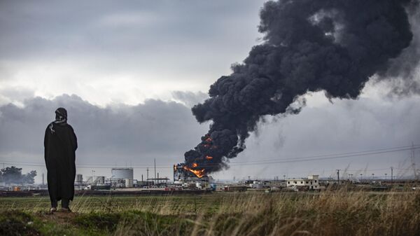 A fumaça espessa surge de um incêndio violento em um tanque de armazenamento das instalações do campo de petróleo de al-Awda, perto de al-Qahtaniyah, no nordeste da Síria, perto da fronteira com a Turquia, em 24 de dezembro de 2023 - Sputnik Brasil