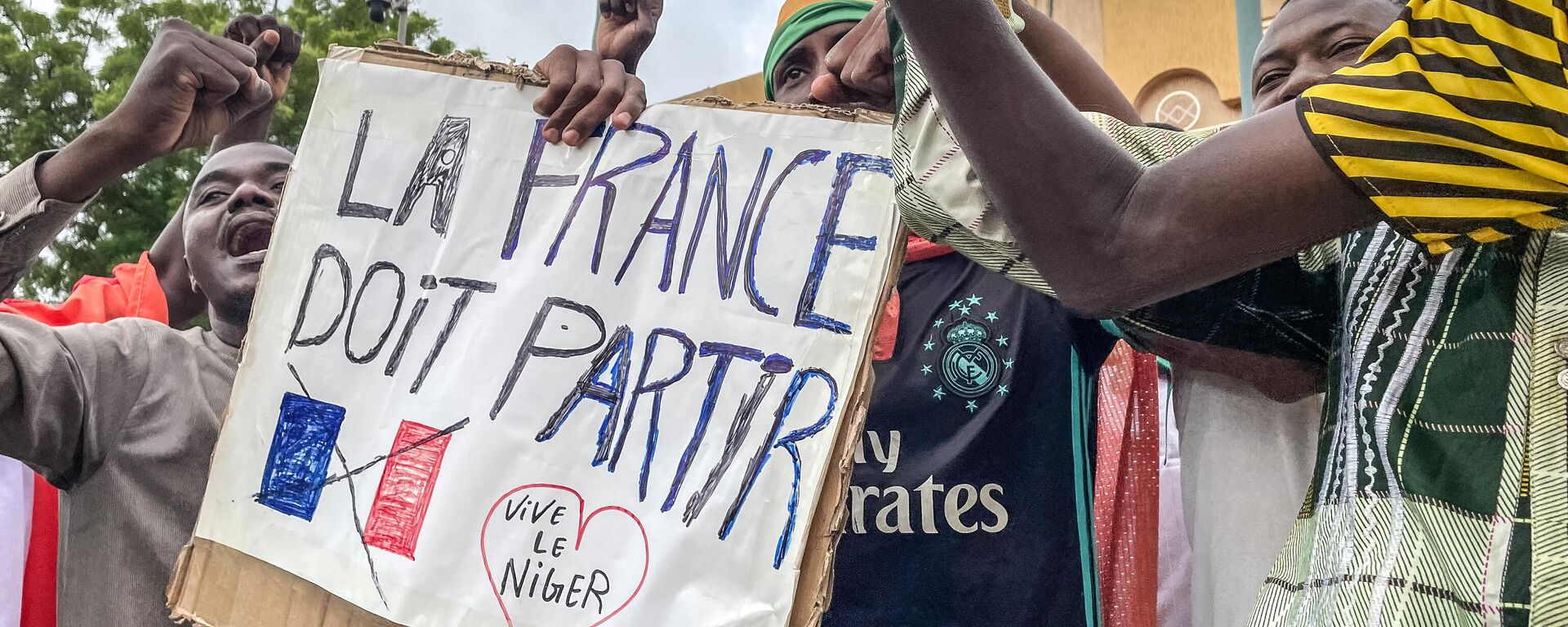 Manifestantes seguram um cartaz anti-França durante uma manifestação no dia da independência em Niamey, em 3 de agosto de 2023. Preocupações de segurança construídas em 3 de agosto de 2023 - Sputnik Brasil, 1920, 02.01.2024