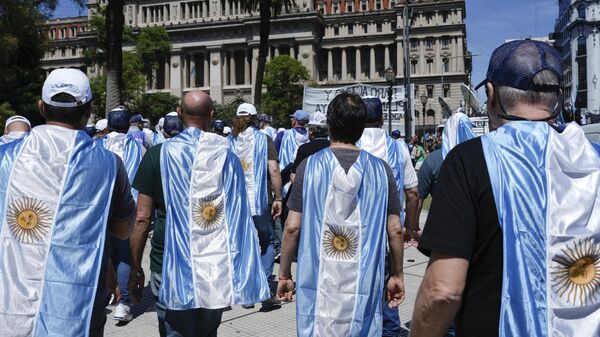 Manifestantes usando bandeiras da Argentina em protesto contra as reformas econômicas do presidente Javier Milei, em 27 de dezembro de 2023 - Sputnik Brasil