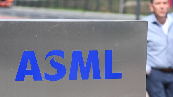 Funcionário passa por logotipo da fabricante de máquinas de criação de chips holandesa ASML, na sede da empresa, em Veldhoven. Países Baixos, 17 de abril de 2018 - Sputnik Brasil