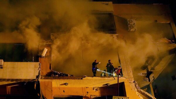 Fumaça sobe de um apartamento destruído enquanto trabalhadores da Defesa Civil procuram sobreviventes após uma grande explosão no subúrbio de Dahiyeh, no sul de Beirute. Líbano, 2 de janeiro de 2024 - Sputnik Brasil