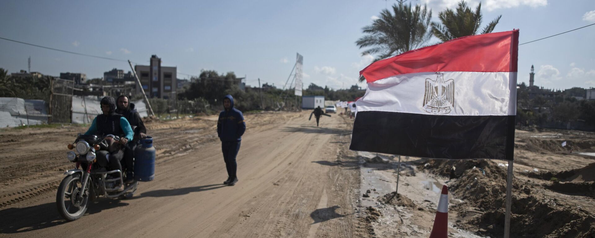 Palestinos passam uma bandeira egípcia na lateral de uma rua em Beit Lahiya, norte da Faixa de Gaza, em 25 de janeiro de 2022. - Sputnik Brasil, 1920, 03.01.2024