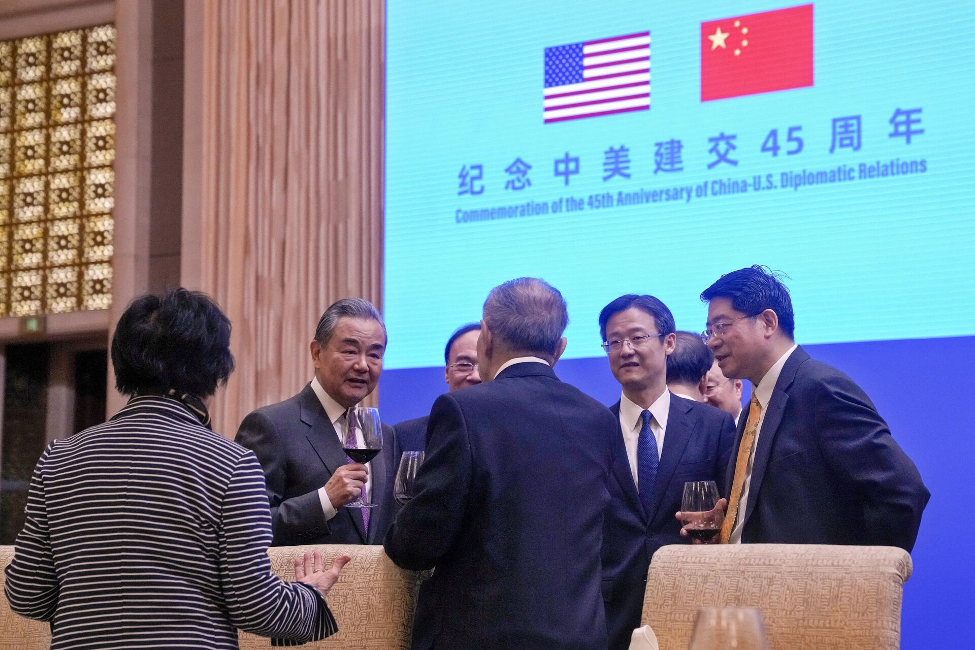 O ministro das Relações Exteriores da China, Wang Yi (segundo à esquerda), fala com convidados após fazer um discurso em uma recepção para comemorar o 45º aniversário das relações diplomáticas China-EUA na Diaoyutai Guest House em Pequim, em 5 de janeiro de 2024 - Sputnik Brasil, 1920, 05.01.2024