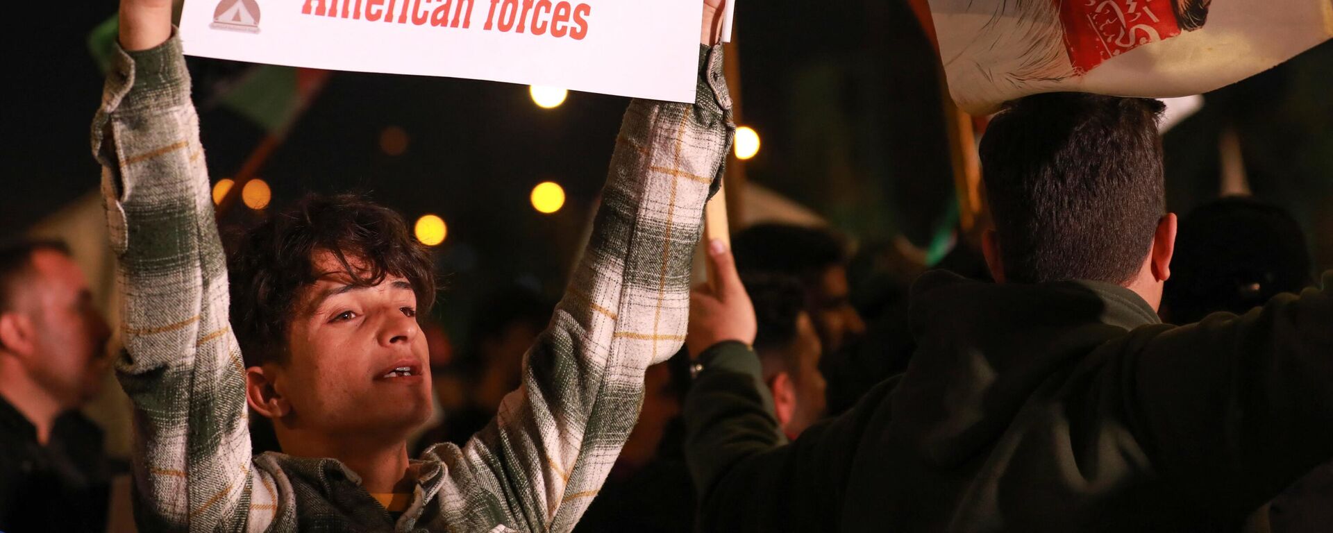 Homem levanta cartaz durante um protesto contra os ataques das forças dos EUA e do Reino Unido contra os rebeldes houthis do Iêmen e contra a presença das forças dos Estados Unidos no Iraque, na praça Tahrir, em Bagdá, Iraque, 13 de janeiro de 2024 - Sputnik Brasil, 1920, 14.01.2024