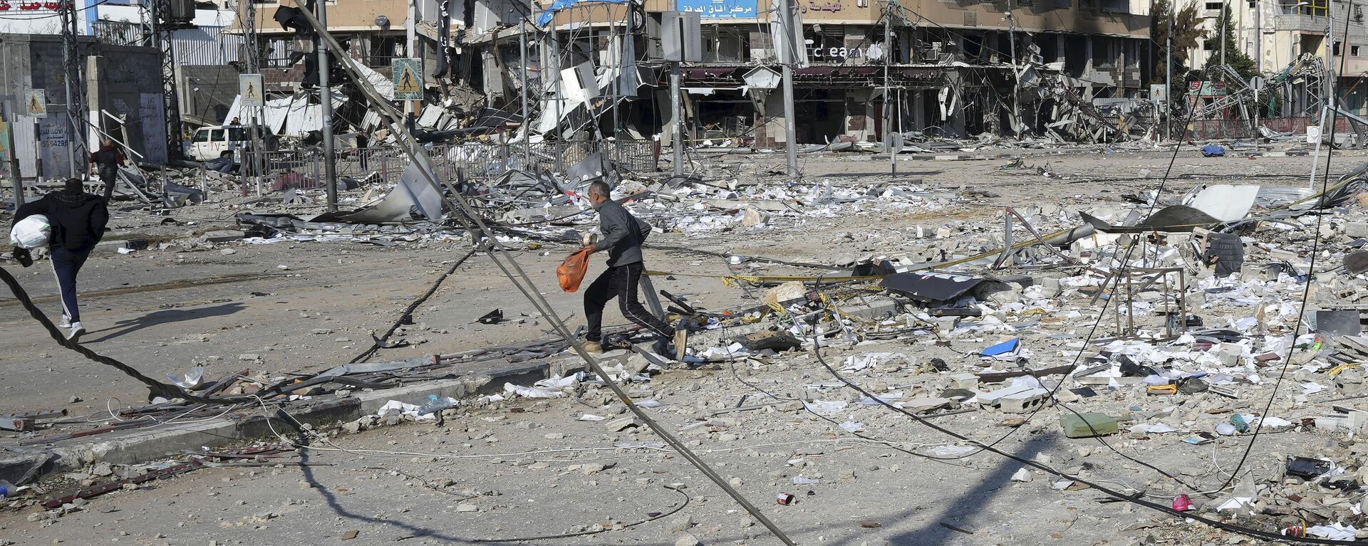 Palestinos passam pela destruição causada por um bombardeio israelense no campo de refugiados de Nusseirat. Faixa de Gaza, 16 de janeiro de 2024 - Sputnik Brasil, 1920, 17.01.2024
