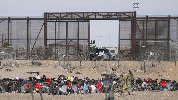 Migrantes em busca de asilo esperam para serem processados pela Patrulha de Fronteira dos EUA após terem cruzado o Rio Grande vindo de Ciudad Juarez, estado de Chihuahua, México, 28 de dezembro de 2023 - Sputnik Brasil