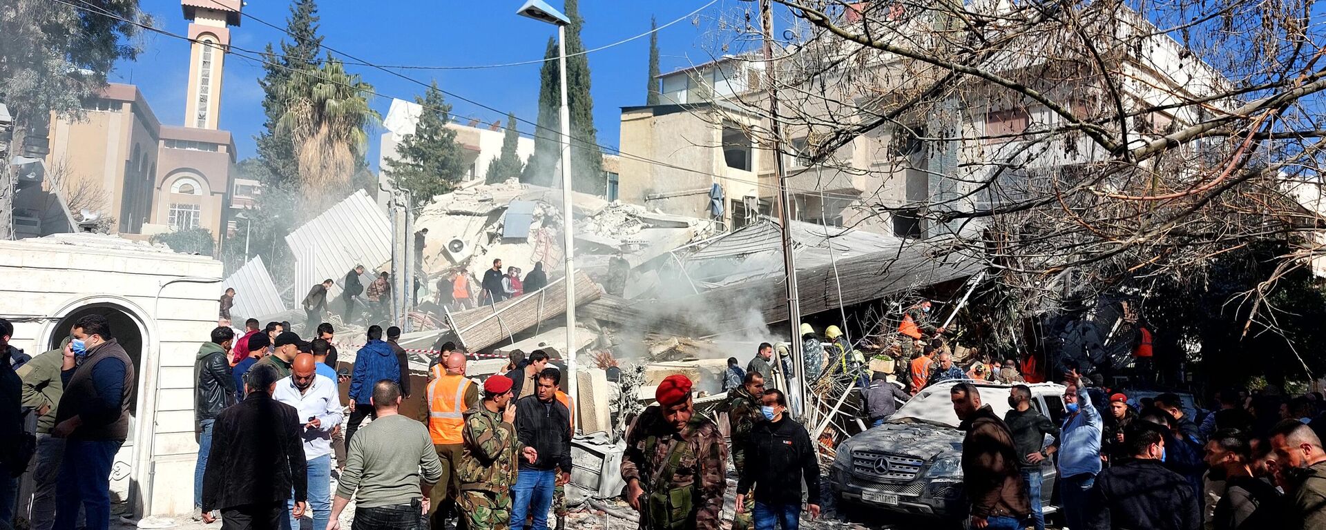 Moradores e forças de segurança se reúnem em frente a prédio destruído em um ataque israelense em Damasco, Síria, 20 de janeiro de 2024 - Sputnik Brasil, 1920, 20.01.2024