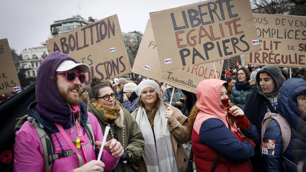 Manifestantes com placas contra o endurecimento das leis de imigração na França. Paris, 21 de janeiro de 2024 - Sputnik Brasil