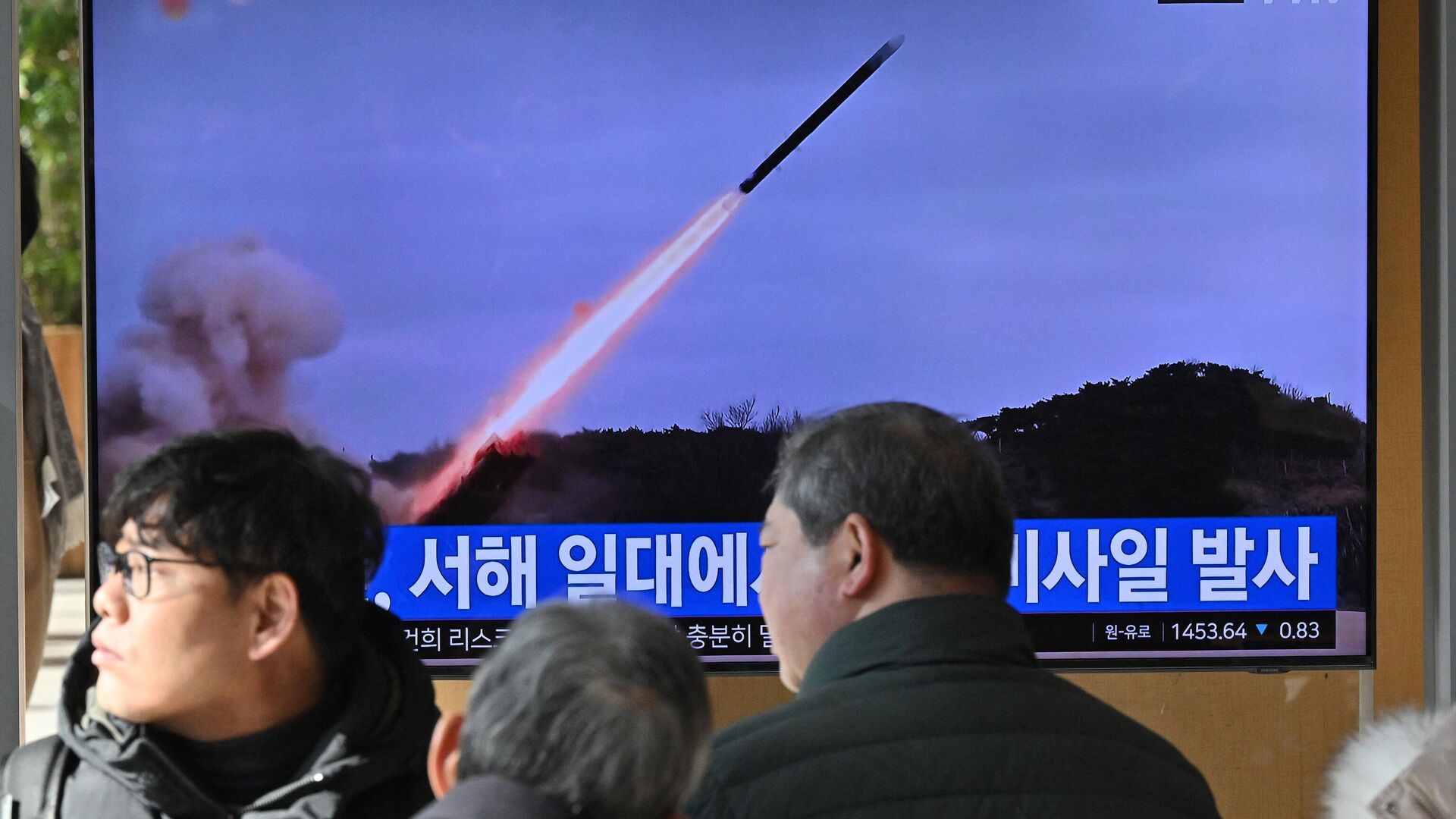 Pessoas assistem a tela televisiva mostrando um noticiário com imagens de arquivo de um teste de míssil norte-coreano, em uma estação de trem em Seul, Coreia do Sul, 24 de janeiro de 2024 - Sputnik Brasil, 1920, 25.01.2024