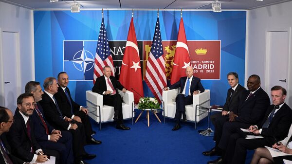 O presidente dos EUA, Joe Biden (C/R), e o presidente da Turquia, Recep Tayyip Erdogan, ladeados por suas respectivas delegações, observam durante uma reunião bilateral à margem da cúpula da OTAN no centro de congressos Ifema, em Madri, em 29 de junho, 2022 - Sputnik Brasil