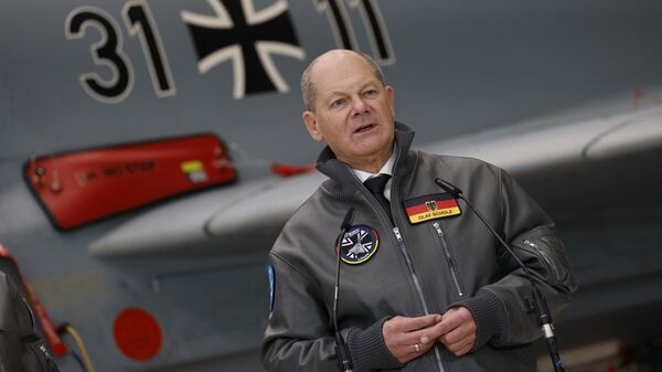 O chanceler alemão Olaf Scholz está em frente a um avião de combate Eurofighter Tycoon enquanto fala durante uma visita à fábrica da Baviera da fabricante de aeronaves europeia Airbus, em 19 de janeiro de 2024 em Manching, sul da Alemanha - Sputnik Brasil