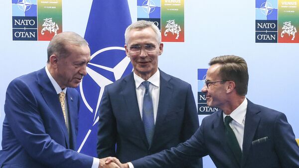 Presidente da Turquia Recep Tayyip Erdogan, aperta as mãos do primeiro-ministro sueco, Ulf Kirstersson, sob os olhares do secretário-geral da OTAN, Jens Stoltenberg, em 10 de julho de 2023 - Sputnik Brasil