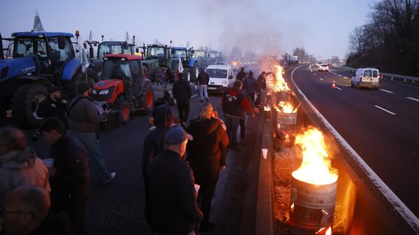 Agricultores acendem fogueiras enquanto bloqueiam uma rodovia perto de Ableiges, ao norte de Paris. França, 26 de janeiro de 2024 - Sputnik Brasil