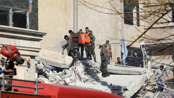 Pessoal de segurança e de emergência vasculha escombros de prédio destruído durante ataque israelense em Damasco. Síria, 20 de janeiro de 2024 - Sputnik Brasil