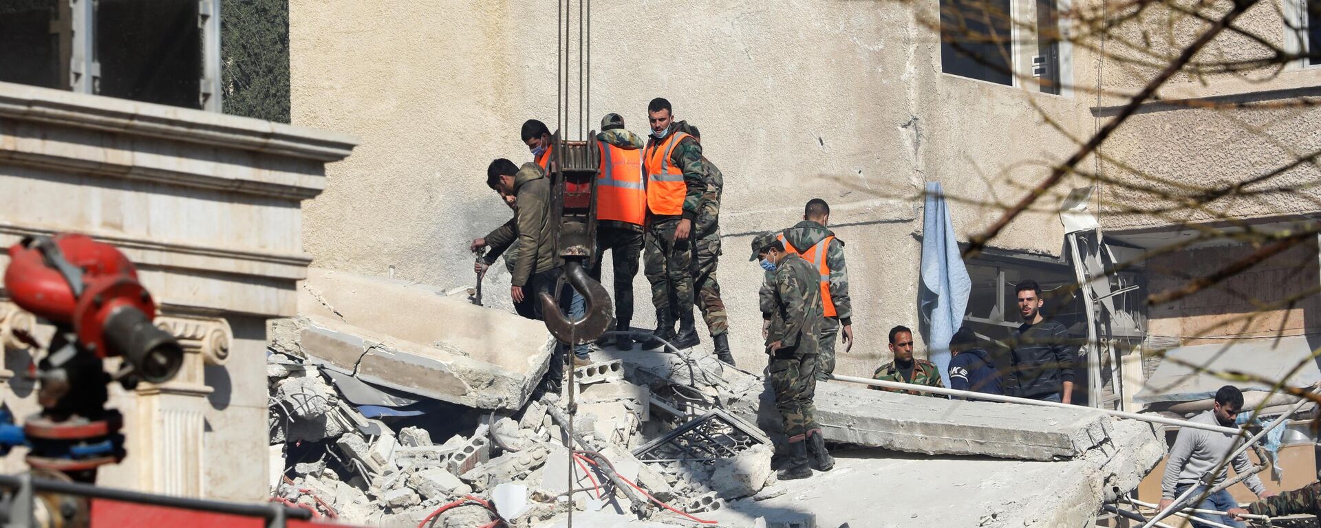 Pessoal de segurança e de emergência vasculha escombros de prédio destruído durante ataque israelense em Damasco. Síria, 20 de janeiro de 2024 - Sputnik Brasil, 1920, 07.02.2024