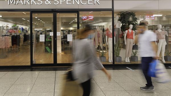 Pessoas passam por uma filial da rede de varejo britânica Marks & Spencer em Londres. A Marks & Spencer alertou que as interrupções no transporte causadas por ataques a navios no mar Vermelho atrasariam as novas coleções de roupas. Reino Unido, 18 de agosto de 2020 - Sputnik Brasil