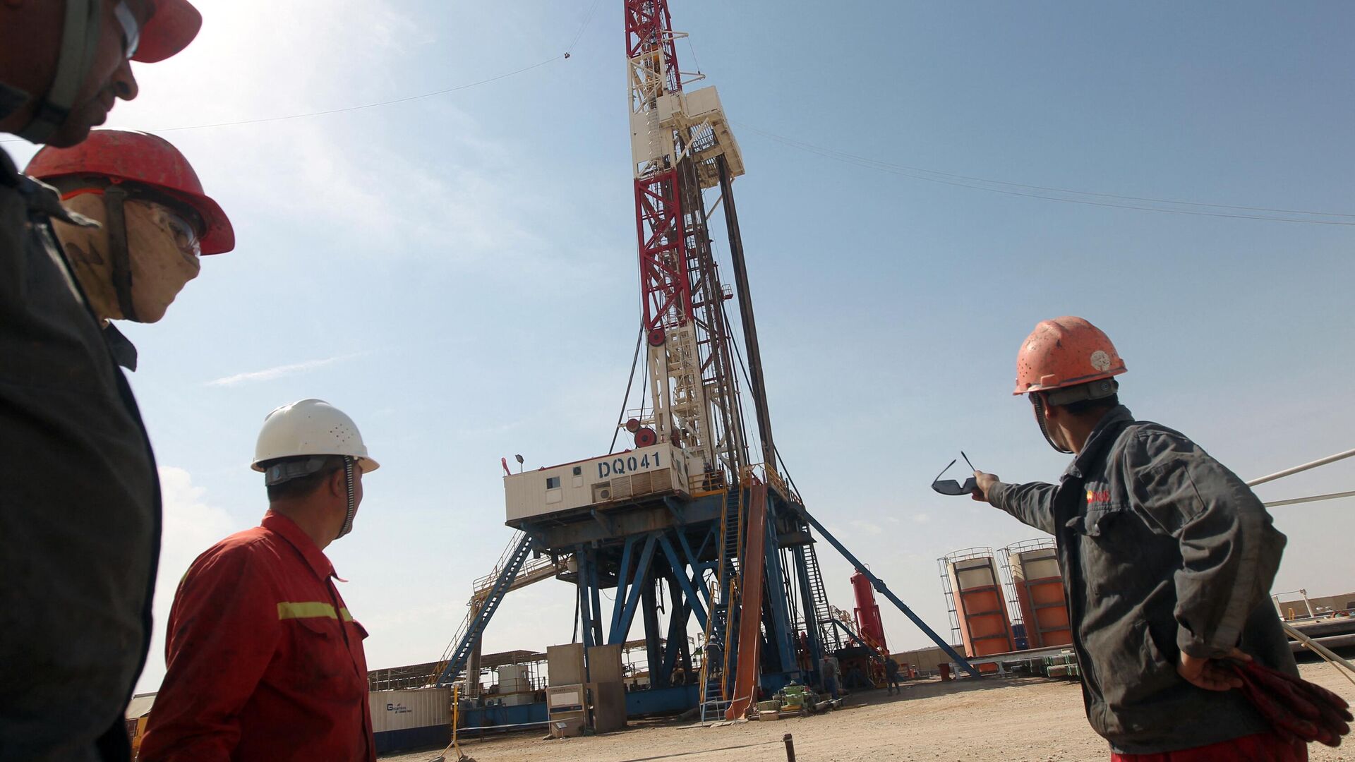 Funcionários da Gazprom observam uma plataforma de perfuração da empresa Gazprom em um campo petrolífero perto da cidade iraquiana de Badra, ao sul de Bagdá, em 18 de outubro de 2012 - Sputnik Brasil, 1920, 07.02.2024