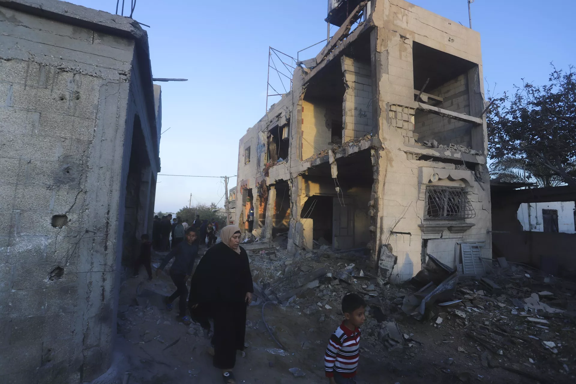 Palestinos passam por prédio residencial destruído em um ataque israelense em Rafah. Faixa de Gaza, 11 de fevereiro de 2024 - Sputnik Brasil, 1920, 15.02.2024