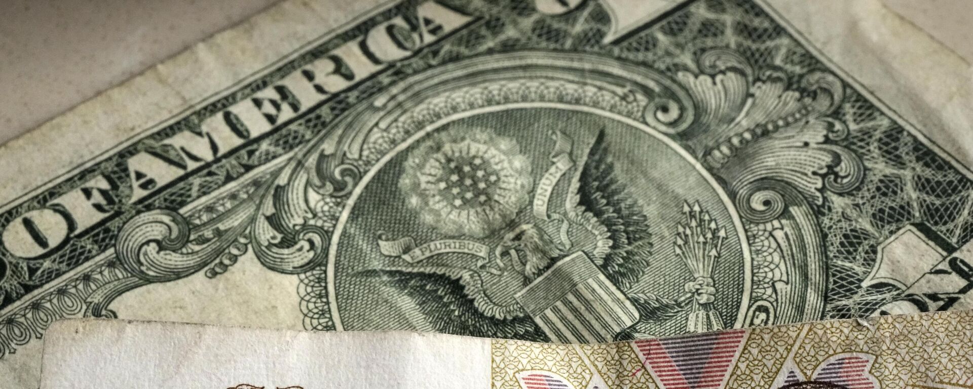 Nota de100 rublos retratada na frente de uma nota de um dólar americano, em Gelsenkirchen, Alemanha, em 25 de abril de 2022 - Sputnik Brasil, 1920, 14.02.2024