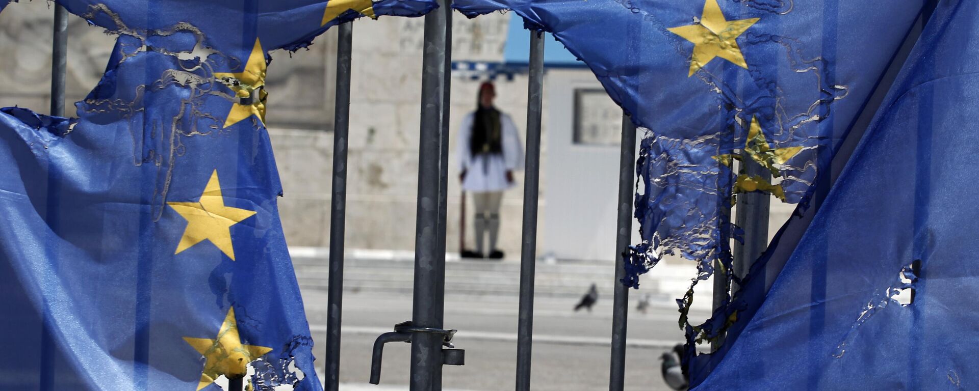 Guarda presidencial grega enquadrada pelos restos de uma bandeira da União Europeia, parcialmente queimada pelos manifestantes em Atenas, 1º de maio de 2013 - Sputnik Brasil, 1920, 15.02.2024