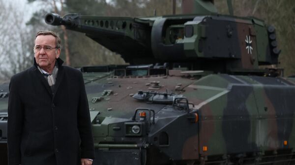 O ministro da Defesa alemão, Boris Pistoriuss, passa por um tanque Puma ao chegar para uma cerimônia de inauguração do futuro local de uma fábrica de material bélico onde o fabricante de armas alemão Rheinmetall planeja iniciar a produção a partir de 2025, em Unterluess, Alemanha, em 12 de fevereiro de 2024 - Sputnik Brasil