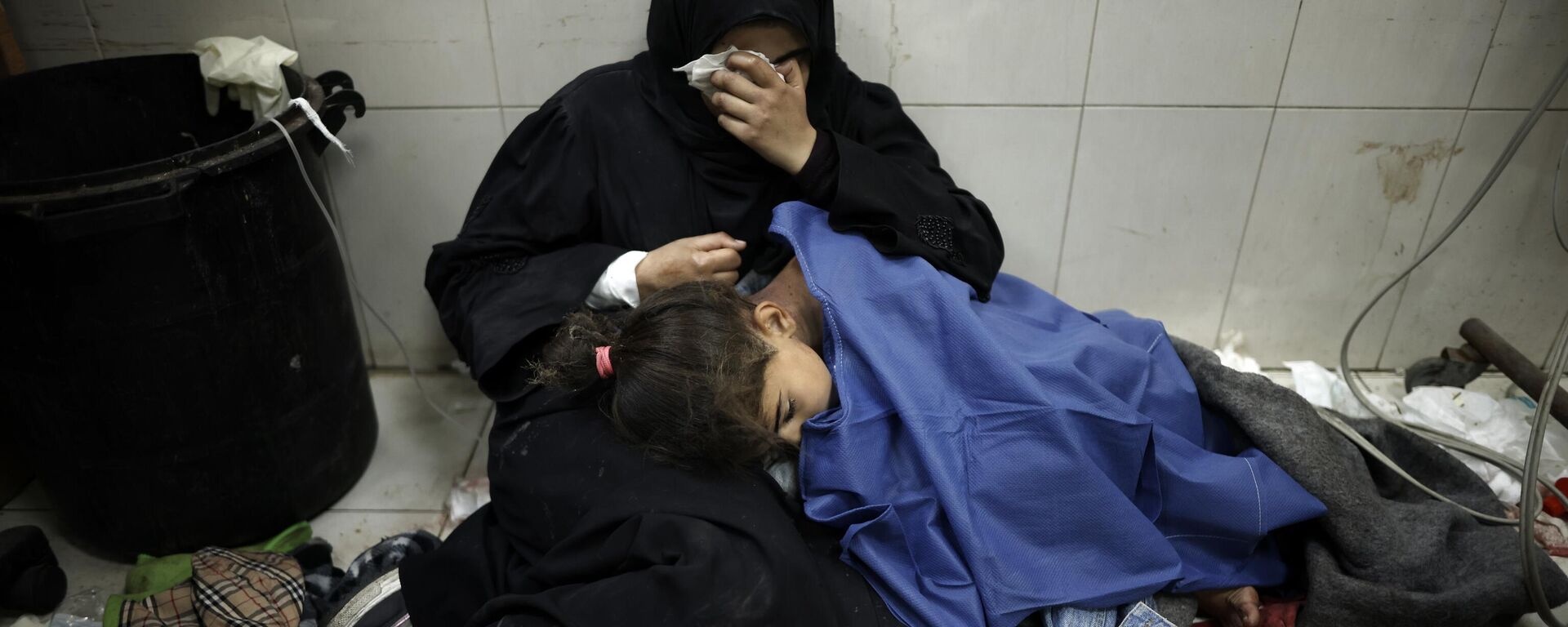 Palestina ao lado da filha ferida após bombardeio israelense no Hospital Nasser, no sul da Faixa de Gaza. Khan Younis, 22 de janeiro de 2024 - Sputnik Brasil, 1920, 18.02.2024