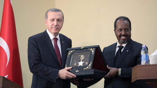 O presidente da Turquia, Recep Tayyip Erdogan, à esquerda, e o presidente da Somália, Hassan Sheikh Mohamud, trocam presentes. Mogadíscio, 25 de janeiro de 2015 - Sputnik Brasil