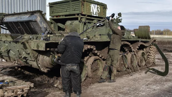 Soldados do batalhão de reparação e recuperação do agrupamento de tropas Vostok (Leste) consertam e modernizam tanque da zona de operação especial da Rússia, foto publicada em 21 de fevereiro de 2024 - Sputnik Brasil