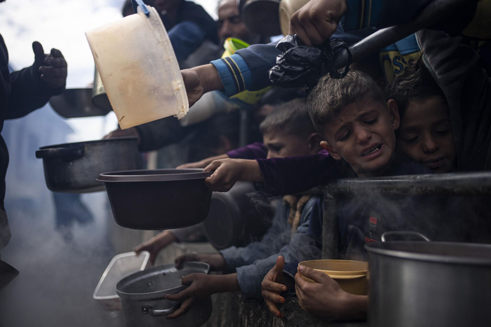 Palestinos fazem fila para refeição fornecida por ajuda humanitária em Rafah. Faixa de Gaza, 16 de fevereiro de 2024 - Sputnik Brasil, 1920, 23.02.2024