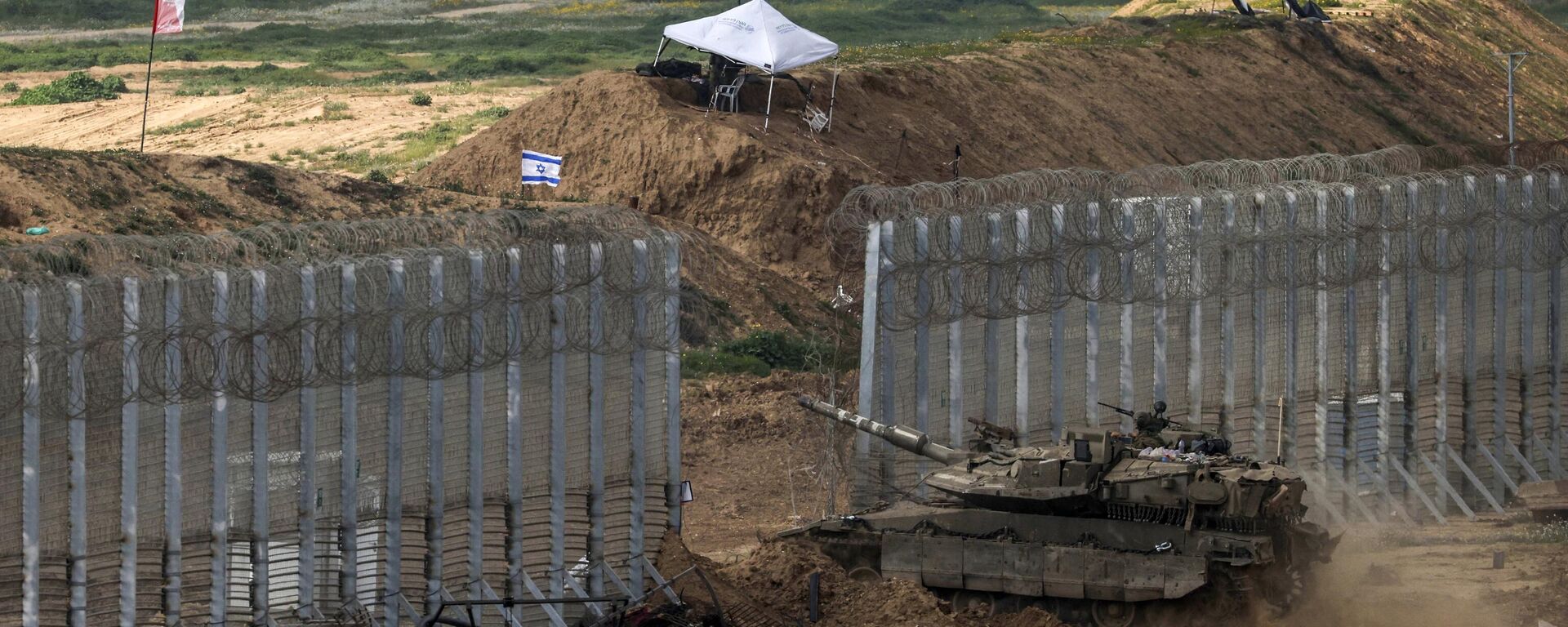 Foto tirada de uma posição no sul de Israel, perto da fronteira com a Faixa de Gaza, mostra um tanque de guerra israelense cruzando a fronteira para o norte de Gaza, em 19 de fevereiro de 2024 - Sputnik Brasil, 1920, 07.03.2024