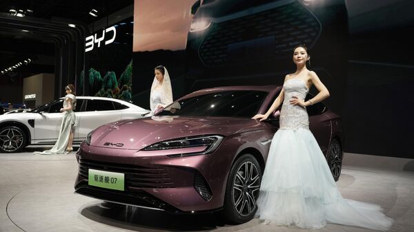 Modelos posam perto da última oferta da montadora chinesa BYD durante o salão Auto Shanghai 2023 em Xangai, em 19 de abril de 2023 - Sputnik Brasil